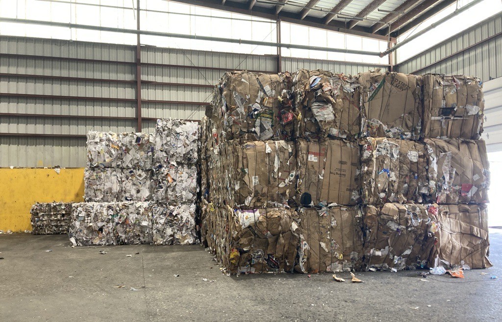 Stacks of bales in a warehouse sorted by type of material.