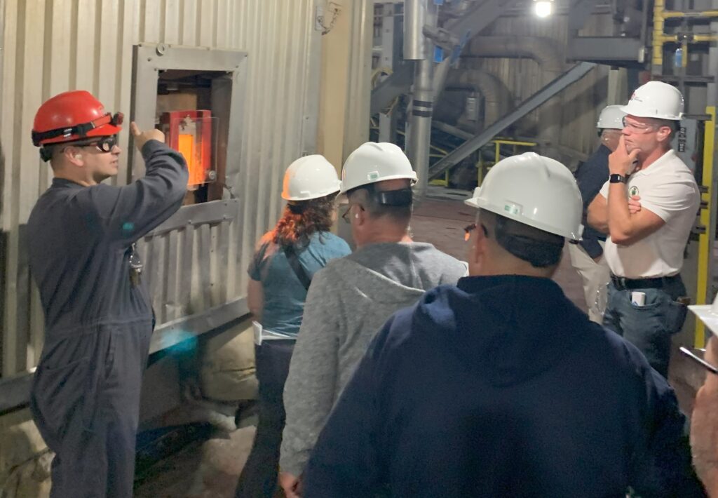 People in hard hats look inside the incinerator